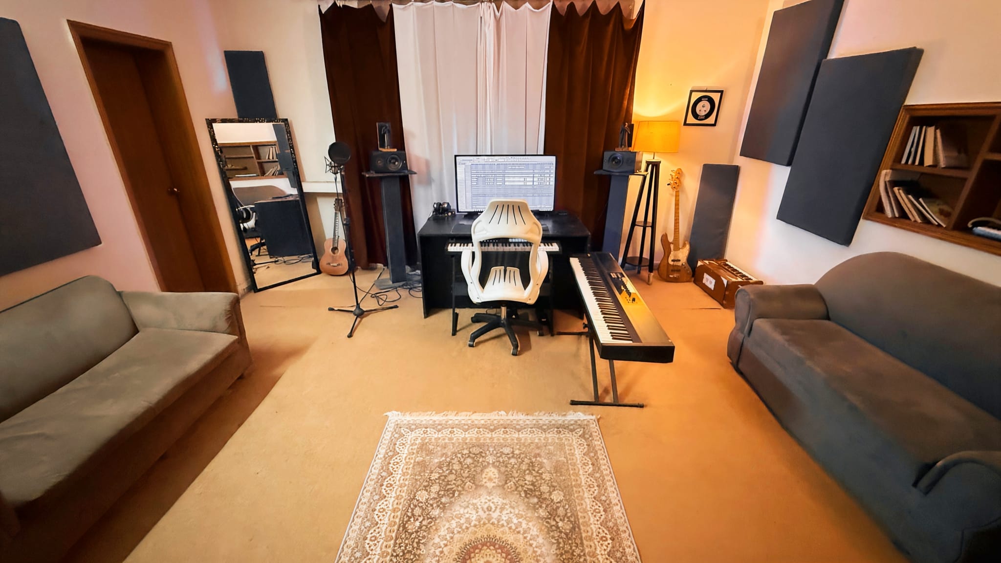 Jazba Studios audio recording room with keyboards, condenser mic, bass guitar and acoustic panelling